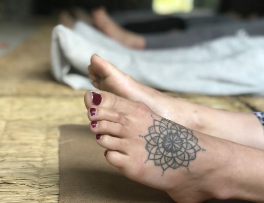 The relaxes feet on mat in Yoga Nidra course