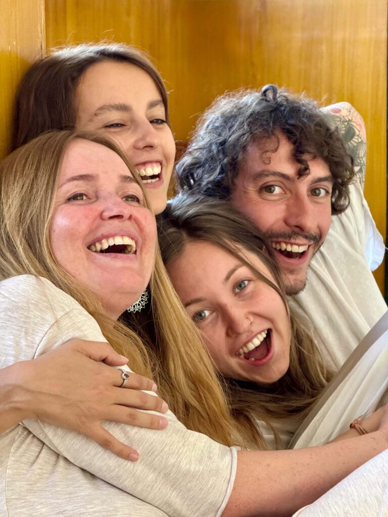 Vedic yoga students smiling and hugging after the group meditation session