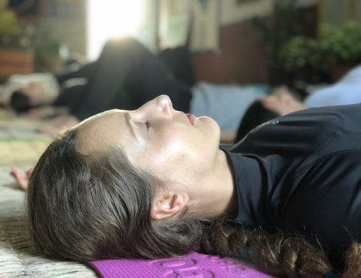 a woman in savasana during yoga nidra class