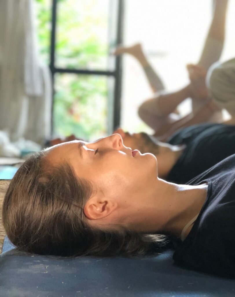 a female student practicing savasana during yoga nidra teacher training
